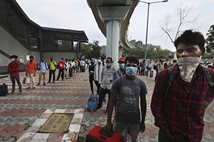 Migrant labourers returning for work queue up to register for COVID-19 tests in New Delhi. (AP)