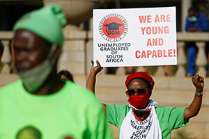 An unemployed graduate in South Africa holds a placard during a demonstration at Church Square in Pretoria.(AFP)